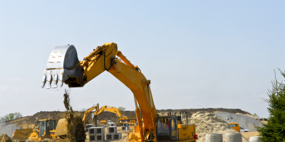 Yellow bulldozer machines digging and moving earth at construction site